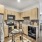 Spacious and well lit kitchen with wood flooring and stainless steel appliances