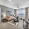 Spacious and well lit living room with wood flooring, large windows and open access to the kitchen