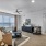 Spacious and well lit living room with wood flooring, large windows and open access to the kitchen