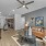Spacious and well lit living room with wood flooring, large windows and open access to the kitchen